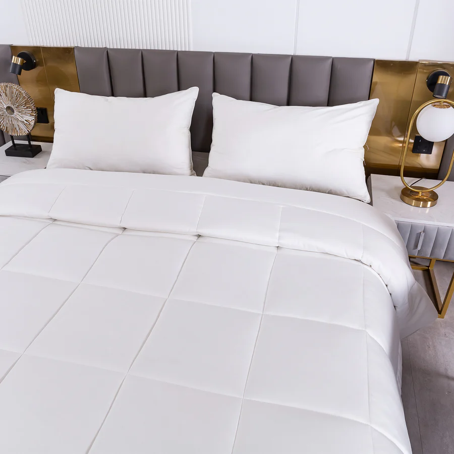 White natural bamboo duvet on a bed with gray headboard and nightstands with lamps.